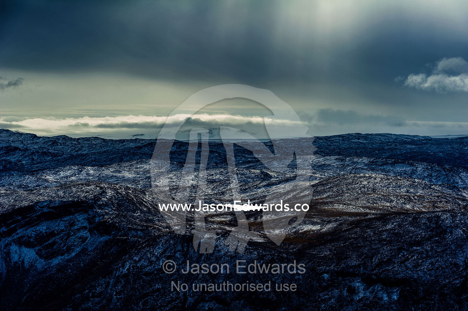 A dusting of snow covers barren and inhospitable mountain peaks on a highland tundra plateau. Tarajornitsut Highlands, Qeqqata Municipality, Kangerlussuaq, Greenland.