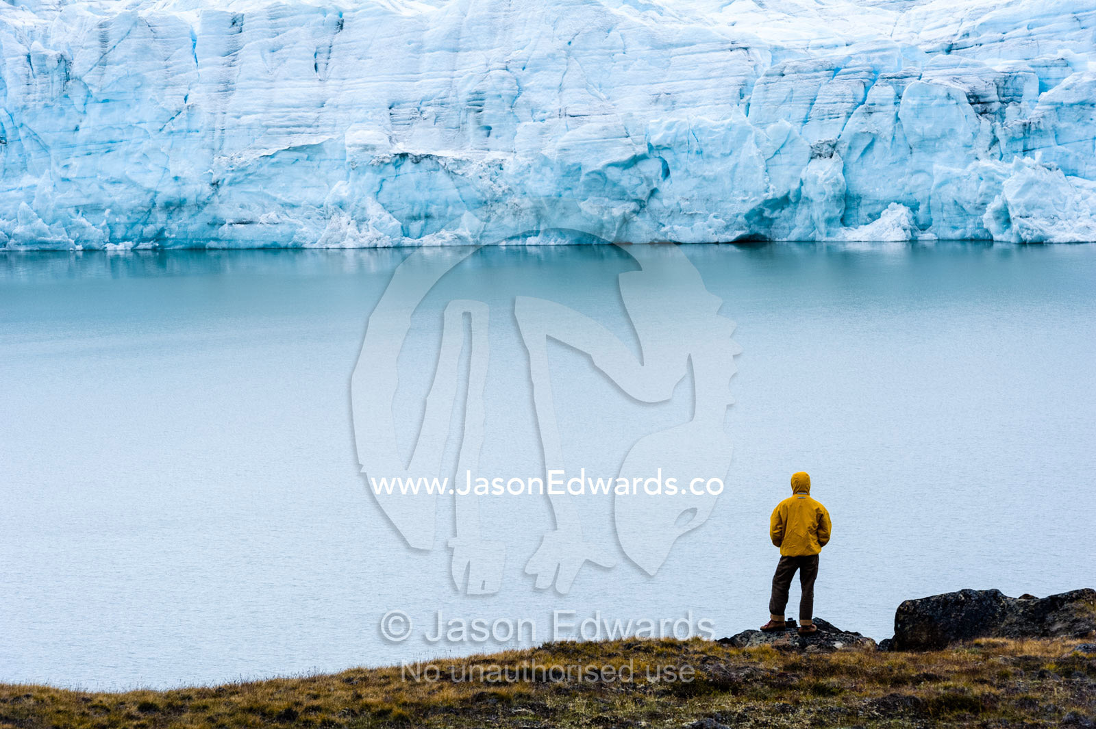 A hiker dwarfed by the fracture zone of a glacier on the Greenland Ice Sheet. Isunngua Highland, Greenland Ice Sheet, Kangerlussuaq, Qeqqata Municipality, Greenland.