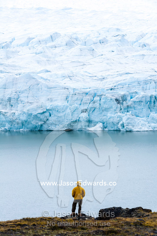 A hiker dwarfed by the fracture zone of a glacier on the Greenland Ice Sheet. Isunngua Highland, Greenland Ice Sheet, Kangerlussuaq, Qeqqata Municipality, Greenland.