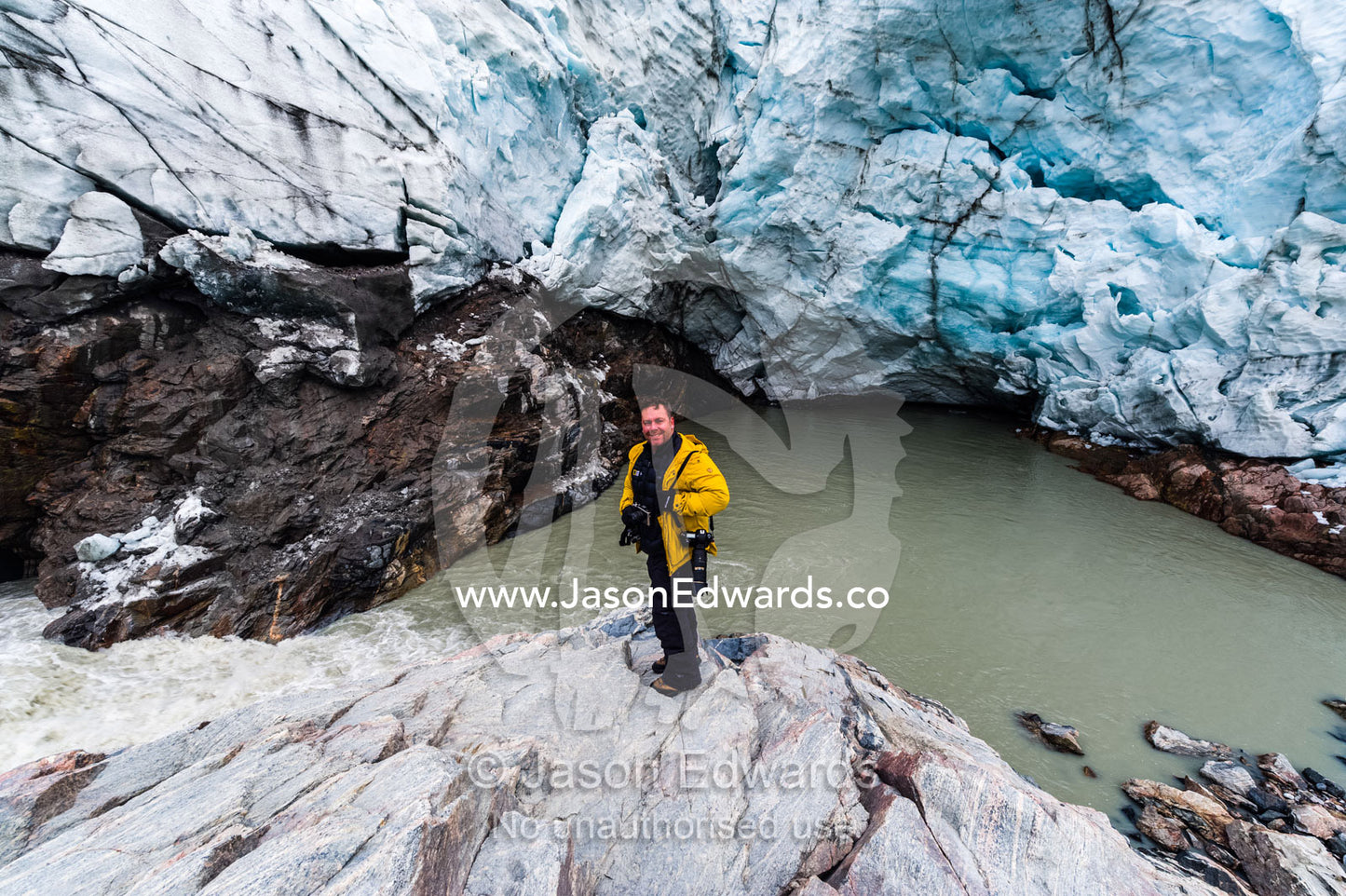 A photographer standing at the base of a glacier fracture zone. Qinnguata Kuussua River, Russell Glacier, Greenland Ice Sheet, Qeqqata Municipality, Kangerlussuaq, Greenland.