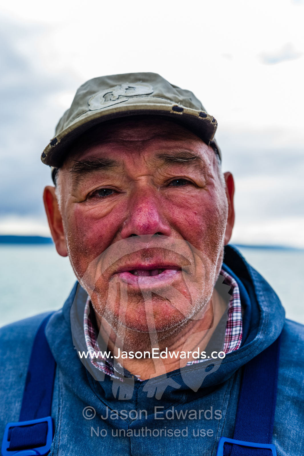 The weathered face of an elderly arctic fisherman. Kangerlussuaq Port, Kangerlussuaq Fjord, Kangerlussuaq, Qeqqata Municipality, Greenland.