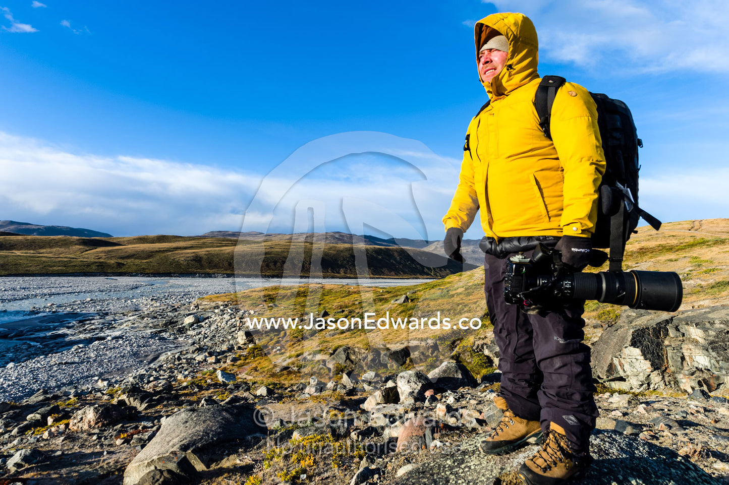 A photographer exploring the windswept tundra at dawn. Russell Glacier, Greenland Ice Sheet, Qeqqata Municipality, Kangerlussuaq, Greenland.