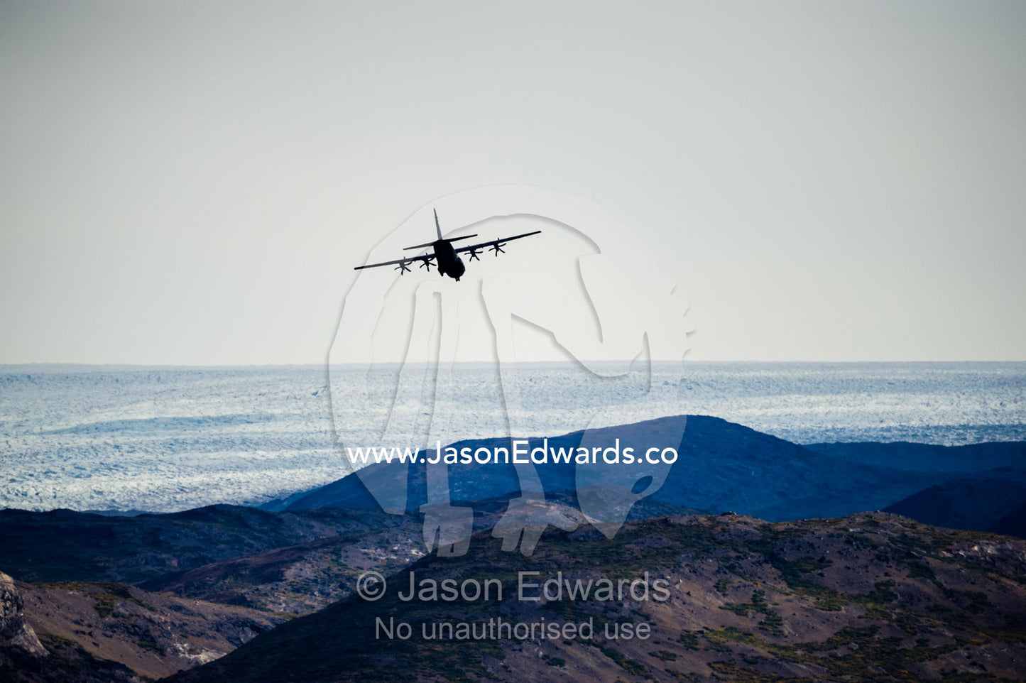 A military Hercules plane flying low over the Greenland Ice Sheet. Russell Glacier, Greenland Ice Sheet, Qeqqata Municipality, Kangerlussuaq, Greenland.