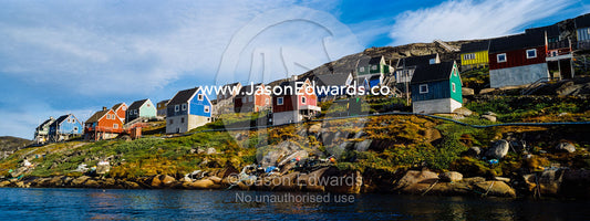 Colorful fishing houses perched on the rocky shoreline of an arctic island. Kangaamiut, Gammel Sukkertoppen, Qeqqata Municipality, Greenland.