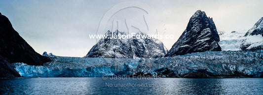 The sheer fracture zone of a glacier sandwiched between alpine peaks in a fjord. Fjord of Eternity, Maniitsoq, Sukkertoppen, Qeqqata Municipality, Greenland.
