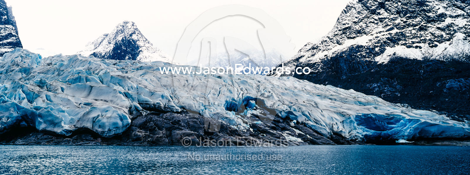 The sheer fracture zone of a glacier sandwiched between alpine peaks in a fjord. Fjord of Eternity, Maniitsoq, Sukkertoppen, Qeqqata Municipality, Greenland.