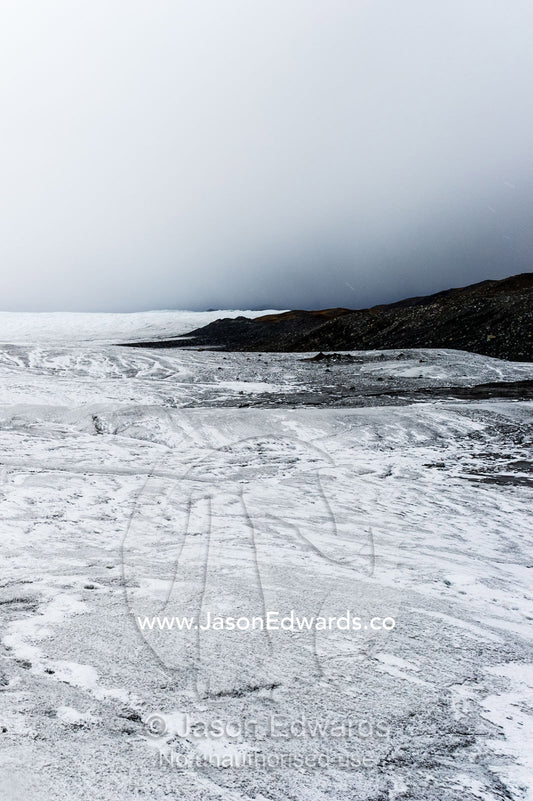 A barren, icy wasteland where the Greenland Ice Sheet presses against a rocky shore. Isunngua Highland, Greenland Ice Sheet, Kangerlussuaq, Qeqqata Municipality, Greenland.