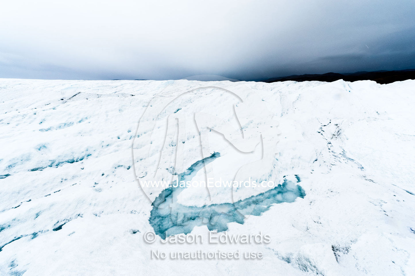 A melt pond on the surface of the Greenland Ice Shelf. Greenland Ice Sheet, Qeqqata Municipality, Kangerlussuaq, Greenland.