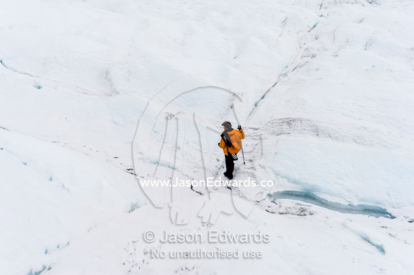 A solitary hiker on the frozen and barren wasteland of folded ice on the Greenland Ice Sheet. Greenland Ice Sheet, Qeqqata Municipality, Kangerlussuaq, Greenland.