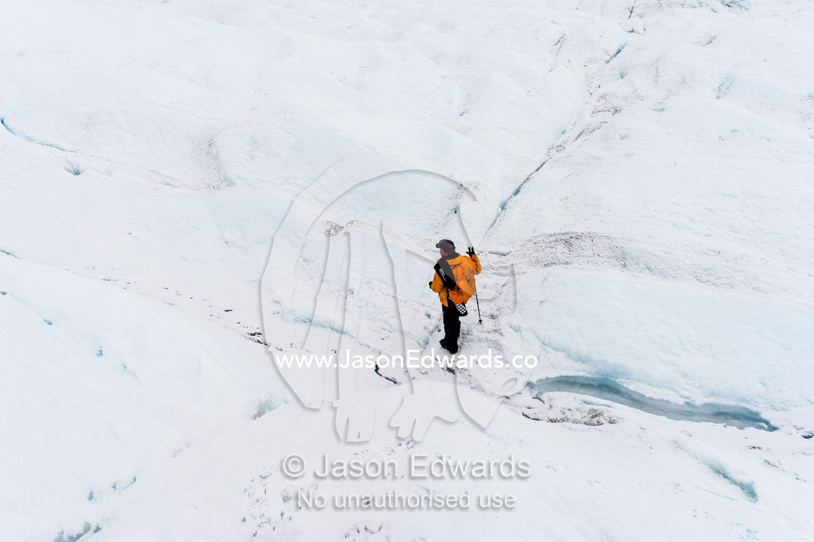 A solitary hiker on the frozen and barren wasteland of folded ice on the Greenland Ice Sheet. Greenland Ice Sheet, Qeqqata Municipality, Kangerlussuaq, Greenland.