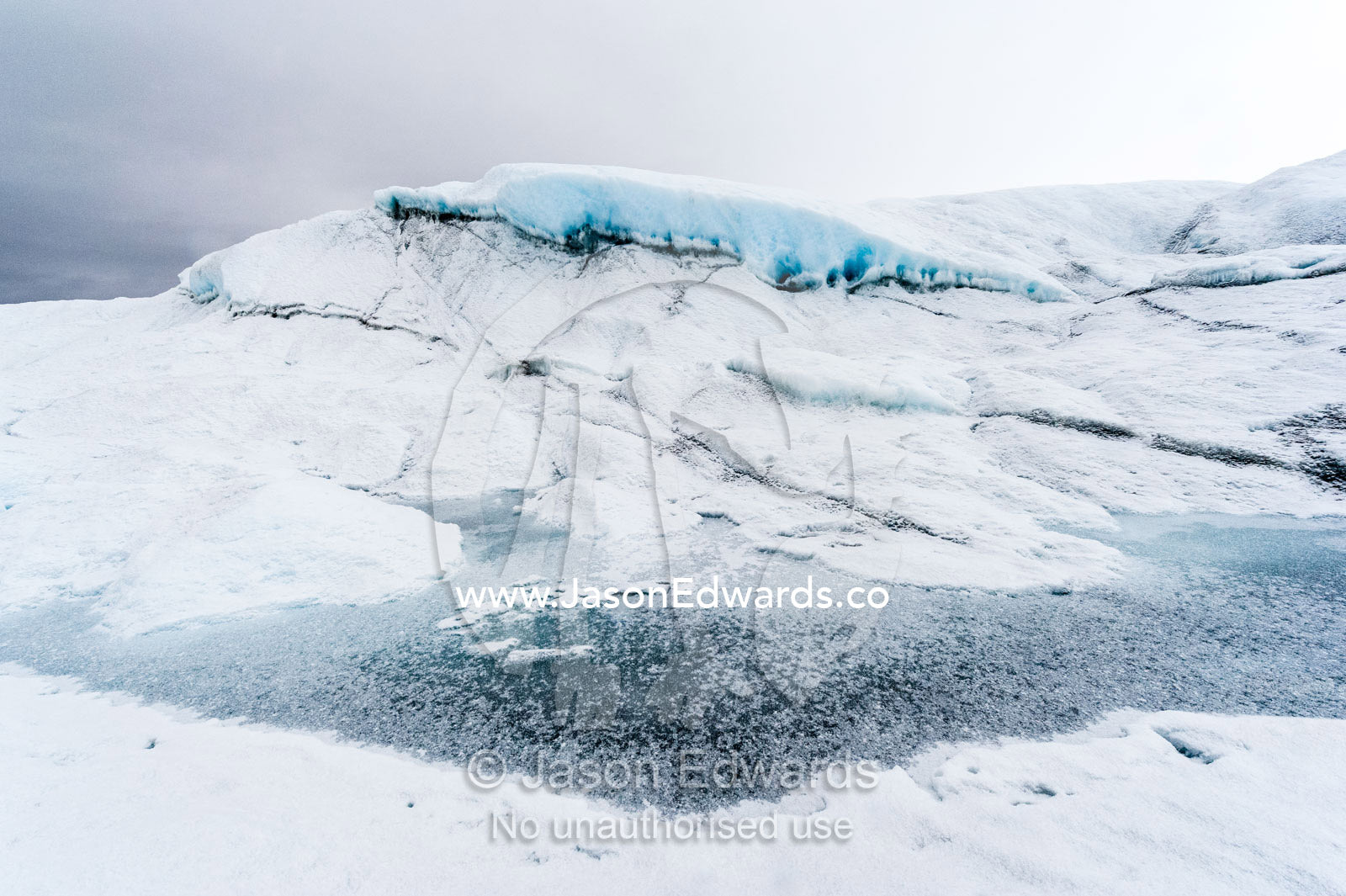 The frozen surface of a melt pond on the surface of the Greenland Ice Shelf. Greenland Ice Sheet, Qeqqata Municipality, Kangerlussuaq, Greenland.