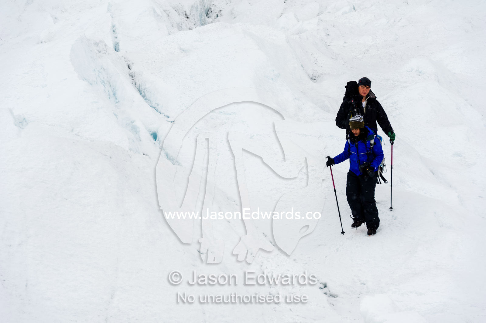 Hikers on the frozen and barren wasteland of folded ice on the surface of the Greenland Ice Sheet. Greenland Ice Sheet, Qeqqata Municipality, Kangerlussuaq, Greenland.