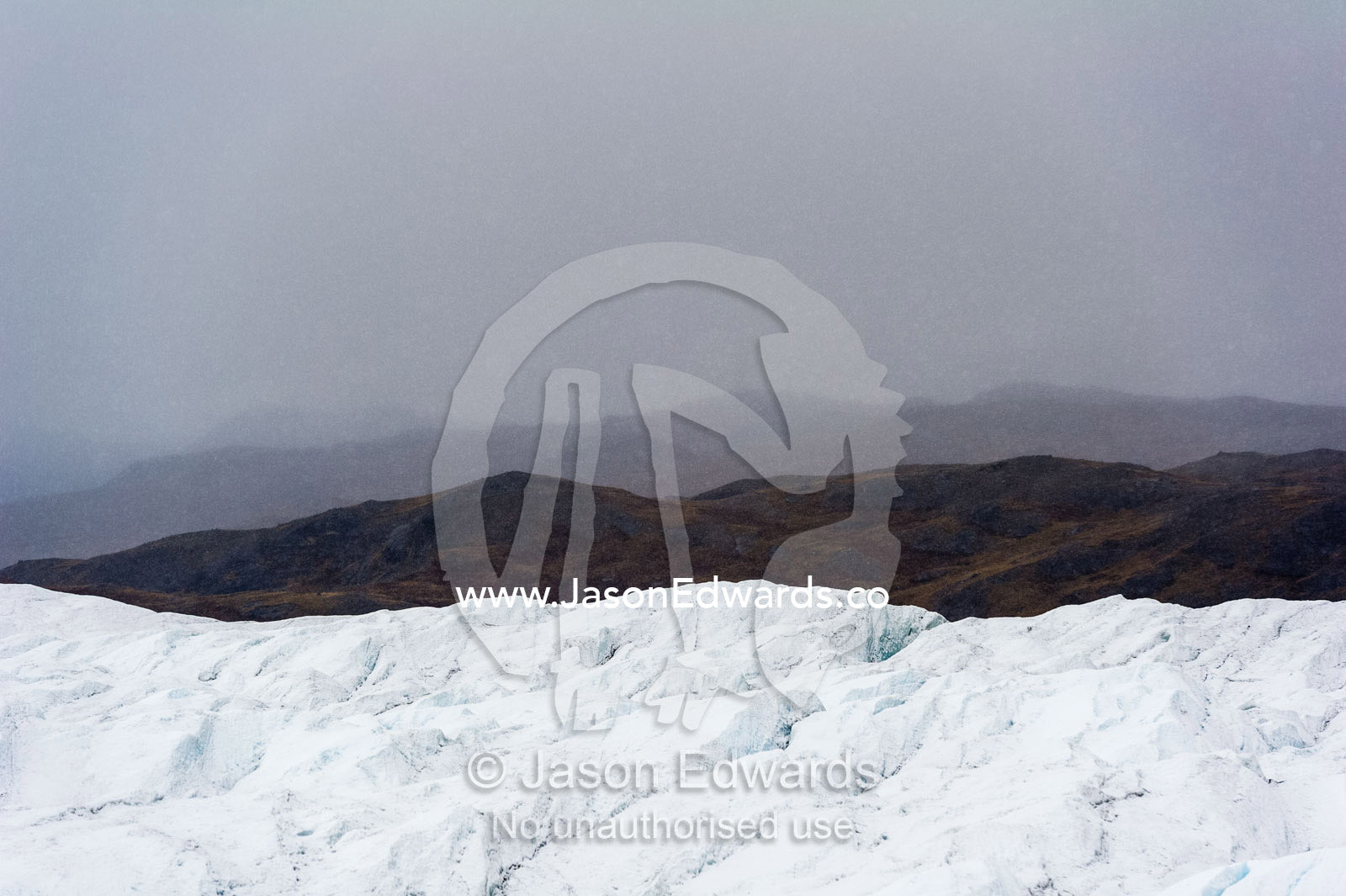 A barren, icy wasteland where the Greenland Ice Sheet presses against a rocky shore. Isunngua Highland, Greenland Ice Sheet, Kangerlussuaq, Qeqqata Municipality, Greenland.