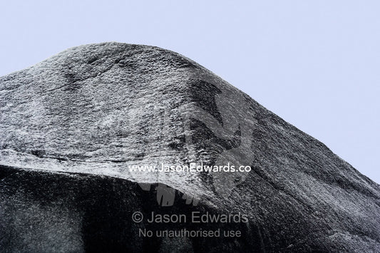 Silt and sediment darkens the surface of a glacier where it's eroding the surrounding rock. Greenland Ice Sheet, Qeqqata Municipality, Kangerlussuaq, Greenland.