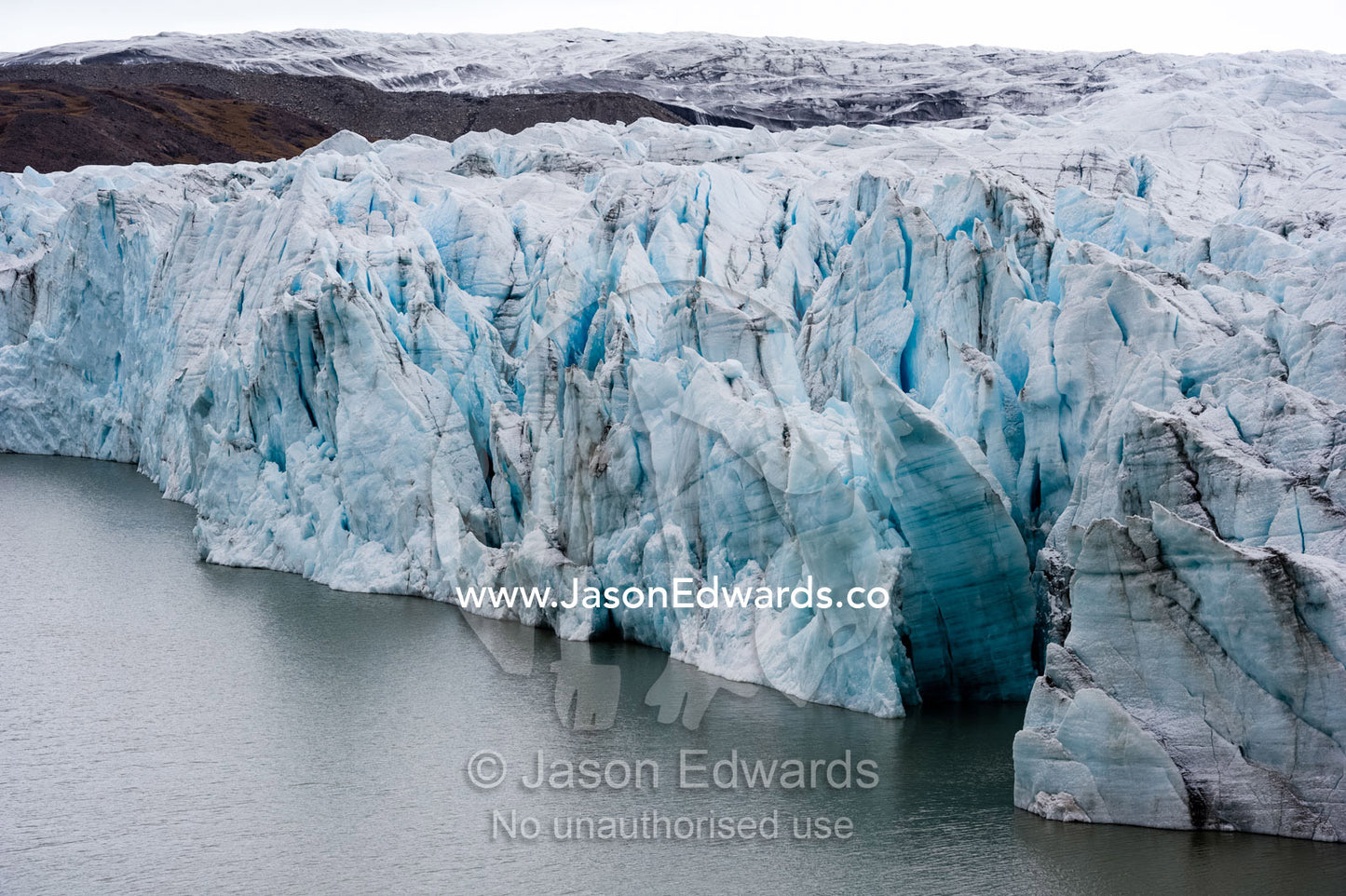 The fracture zone of a glacier on the Greenland Ice Sheet ending in a lake. Greenland Ice Sheet, Qeqqata Municipality, Kangerlussuaq, Greenland.