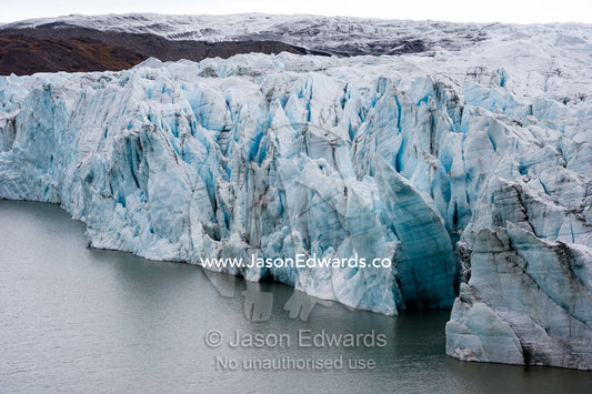The fracture zone of a glacier on the Greenland Ice Sheet ending in a lake. Greenland Ice Sheet, Qeqqata Municipality, Kangerlussuaq, Greenland.