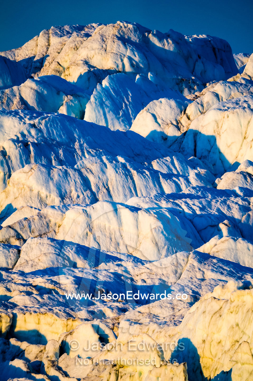 Pastel hues across a field of crevasse and pressure ridges in the fracture zone of a glacier. Russell Glacier, Greenland Ice Sheet, Qeqqata Municipality, Kangerlussuaq, Greenland.