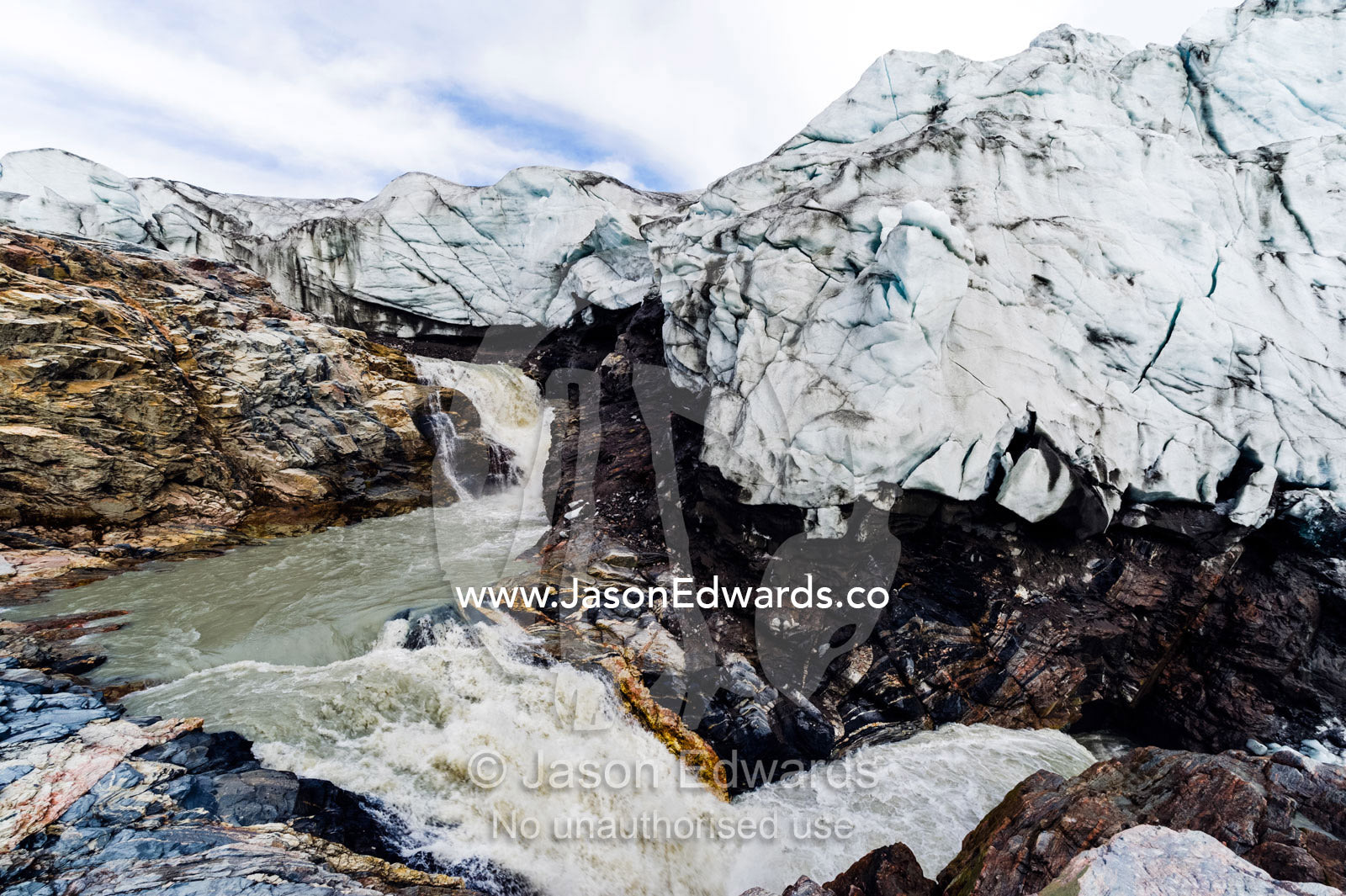 A waterfall of meltwater cascades from beneath a glacier fracture zone. Qinnguata Kuussua River, Russell Glacier, Greenland Ice Sheet, Qeqqata Municipality, Kangerlussuaq, Greenland.