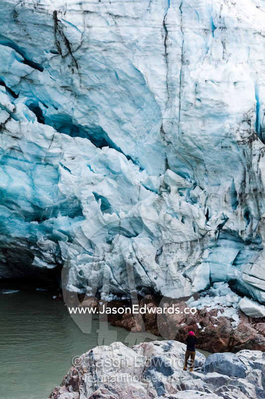 A hiker photographs a glacier fracture zone from a dangerous position beneath the ice. Qinnguata Kuussua River, Russell Glacier, Greenland Ice Sheet, Qeqqata Municipality, Kangerlussuaq, Greenland.