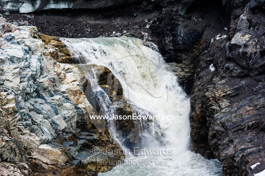 A waterfall of meltwater cascades from beneath a glacier fracture zone. Qinnguata Kuussua River, Russell Glacier, Greenland Ice Sheet, Qeqqata Municipality, Kangerlussuaq, Greenland.