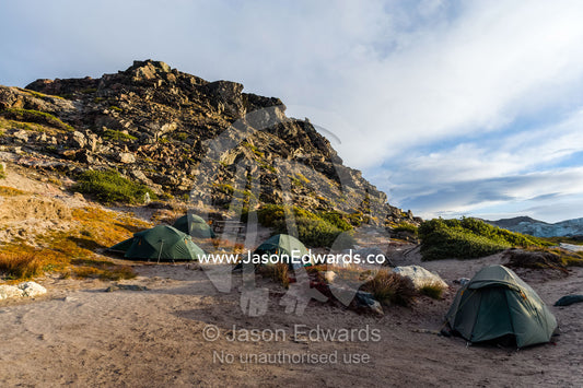 A tented campsite in the shadow of a hill on the arctic tundra. Russell Glacier, Greenland Ice Sheet, Qeqqata Municipality, Kangerlussuaq, Greenland.