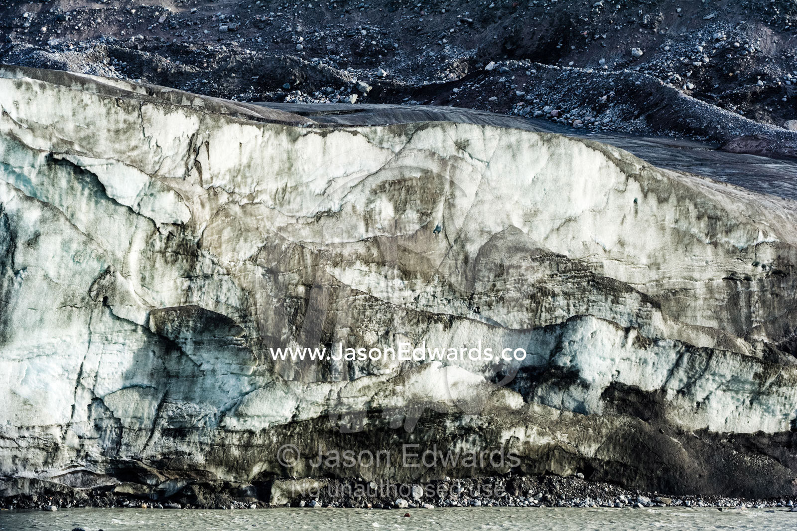Erosion from ice against rock deposits silt and soil sediment on the edges of ice blades along the fracture zone of a glacier. Qinnguata Kuussua River, Russell Glacier, Greenland Ice Sheet, Qeqqata Municipality, Kangerlussuaq, Greenland.