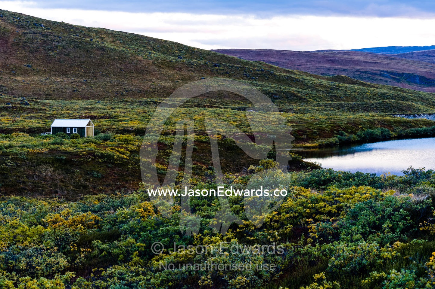 A small cottage on the shores of a remote alpine lake. Sugarloaf Mountain, Kangerlussuaq, Qeqqata Municipality, Greenland.
