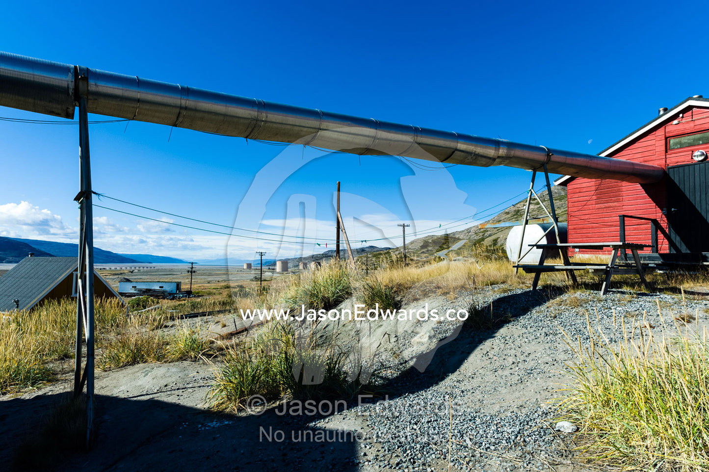 Stainless steel heating pipes run between homes in an arctic village. Kangerlussuaq, Qeqqata Municipality, Greenland.