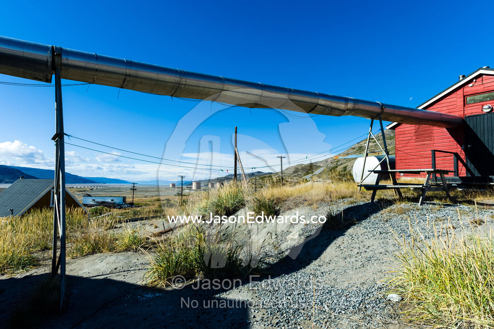 Stainless steel heating pipes run between homes in an arctic village. Kangerlussuaq, Qeqqata Municipality, Greenland.