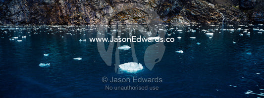 Crushed ice from a glacier fall floating on the ocean surface in a fjord. Fjord of Eternity, Maniitsoq, Sukkertoppen, Qeqqata Municipality, Greenland.