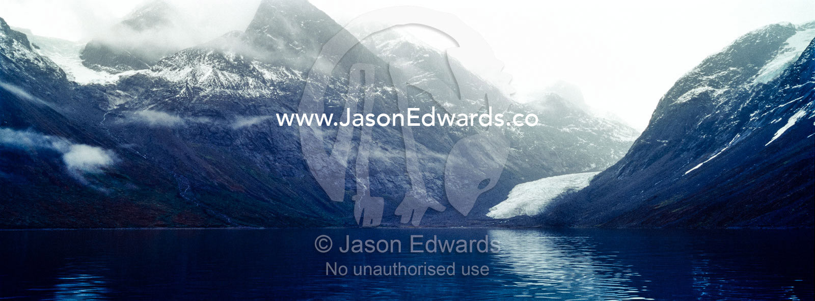 A jagged glacier tongue recedes up and rugged and inhospitable mountain gorge in a fiord. Fjord of Eternity, Maniitsoq, Sukkertoppen, Qeqqata Municipality, Greenland.