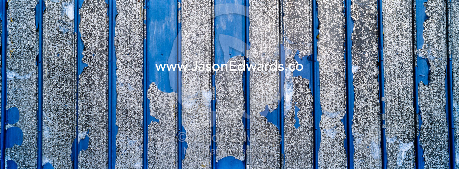 Peeling blue paint on the galvanised tin wall of a factory. Kangerlussuaq, Qeqqata Municipality, Greenland.