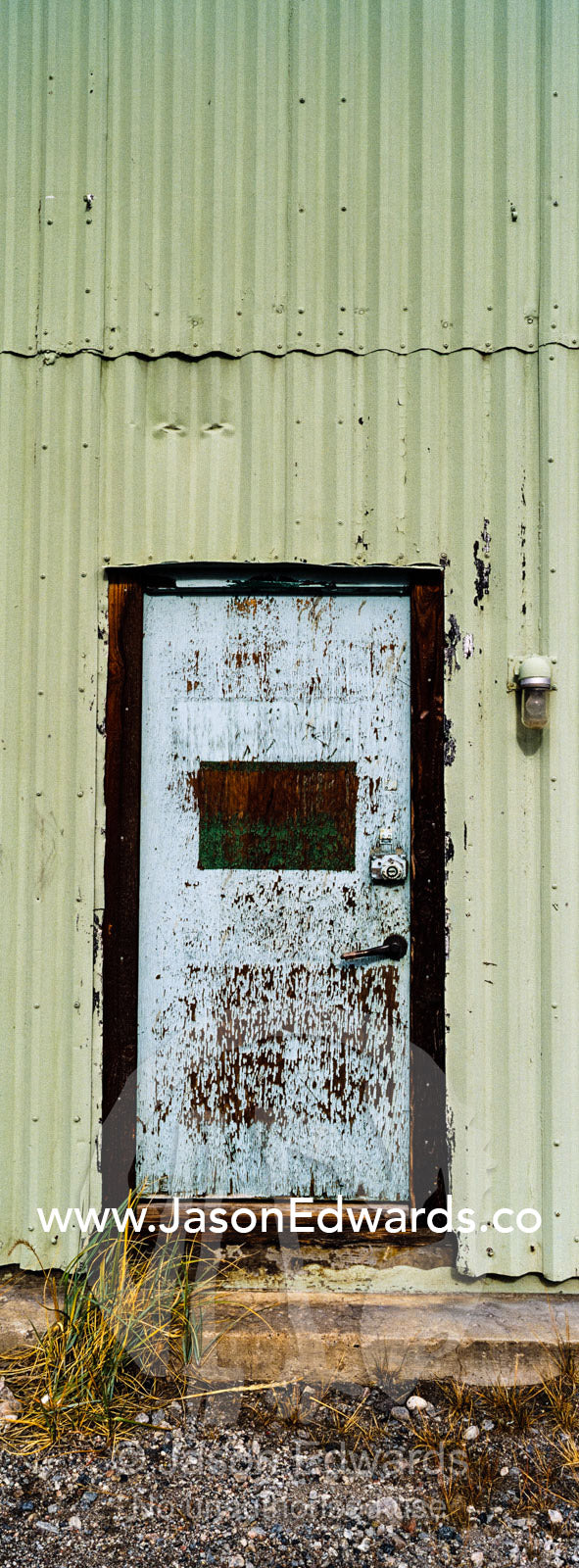 A corrugated tin wall and steel door in an old factory. Kangerlussuaq, Qeqqata Municipality, Greenland.