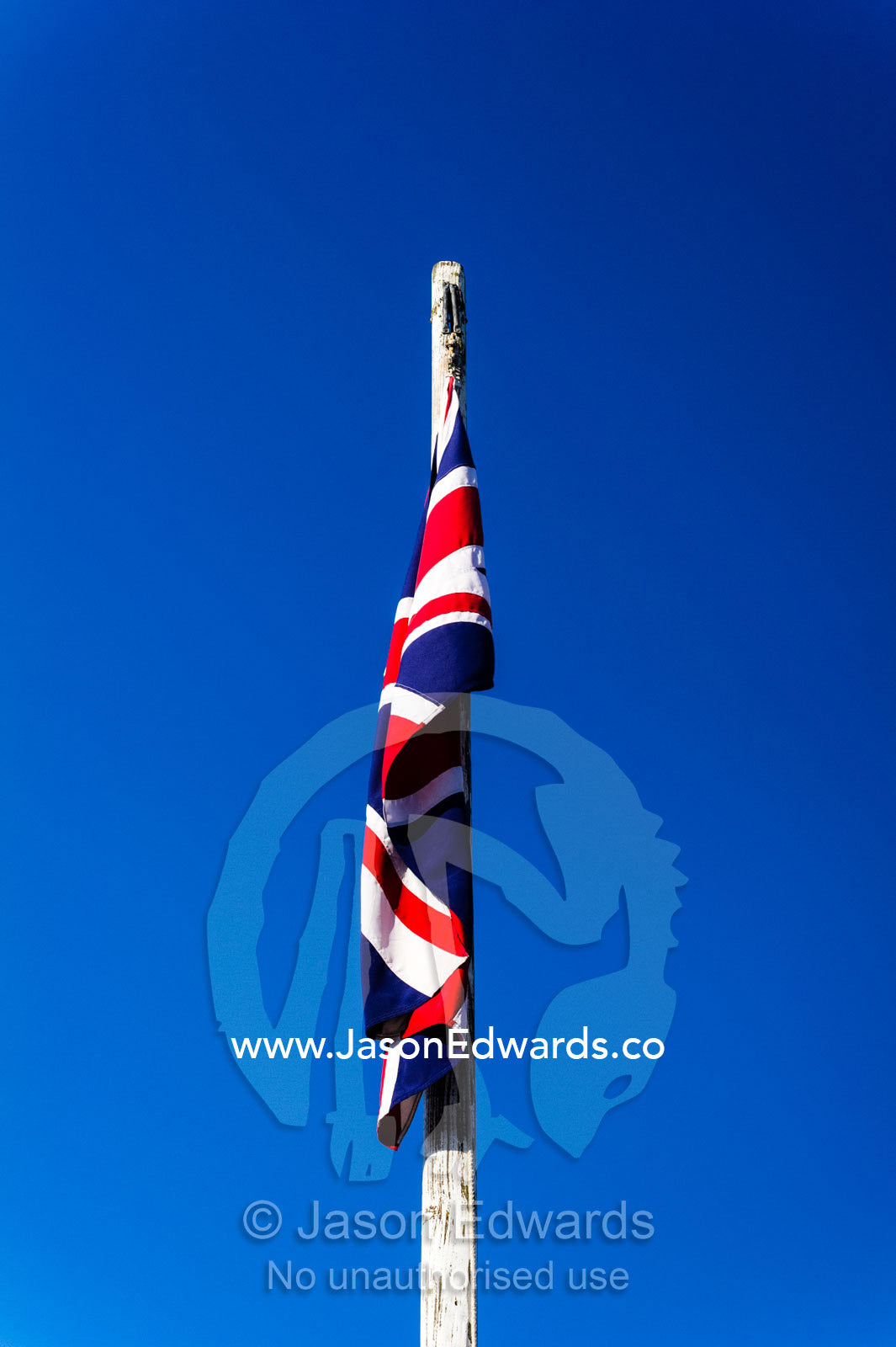 A British Union Jack flag hangs limp on a windless sunny day in a gold town museum. Sovereign Hill, Ballarat, Victoria, Australia.