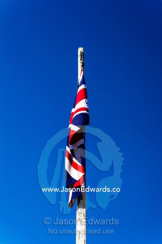 A British Union Jack flag hangs limp on a windless sunny day in a gold town museum. Sovereign Hill, Ballarat, Victoria, Australia.