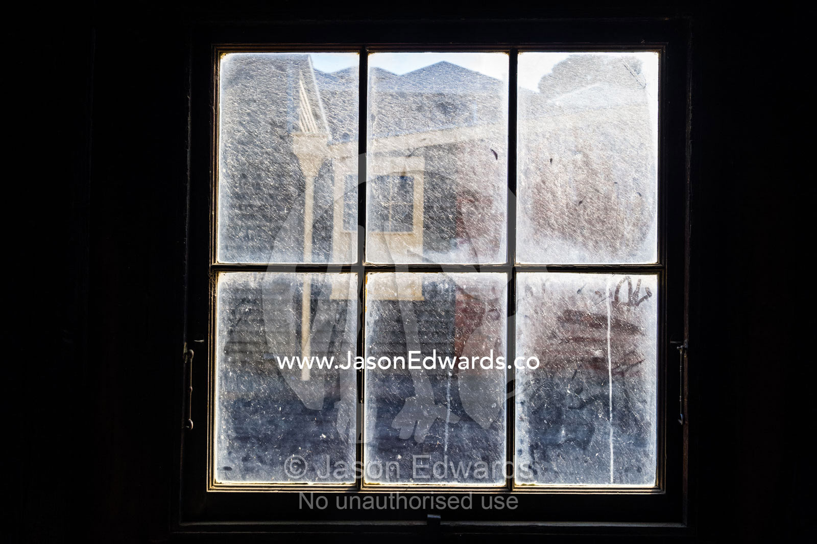 A dirty antique pane window at the Empire Bowling Saloon. Sovereign Hill, Ballarat, Victoria, Australia.