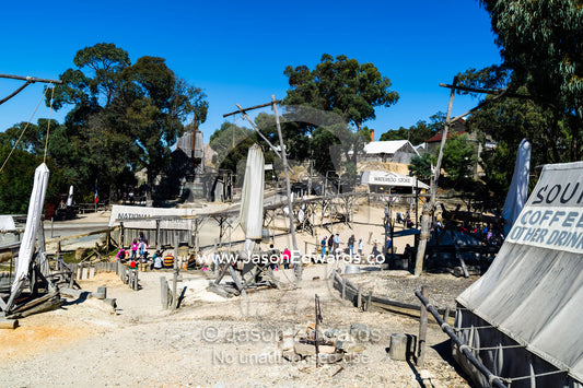 Colonial gold mine diggings and tents around a stream in a gold town museum. Sovereign Hill, Ballarat, Victoria, Australia.
