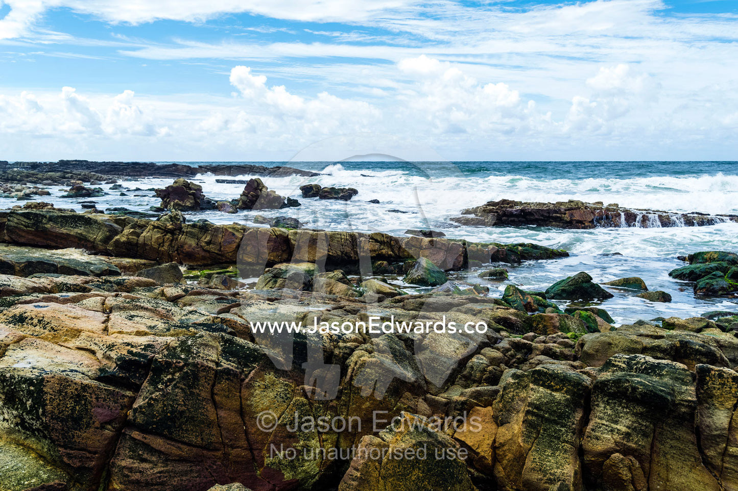 Waves wash over tidal pools and rock slabs on a rugged coastline. Point Arkwright, Yaroomba Beach, Queensland, Australia.