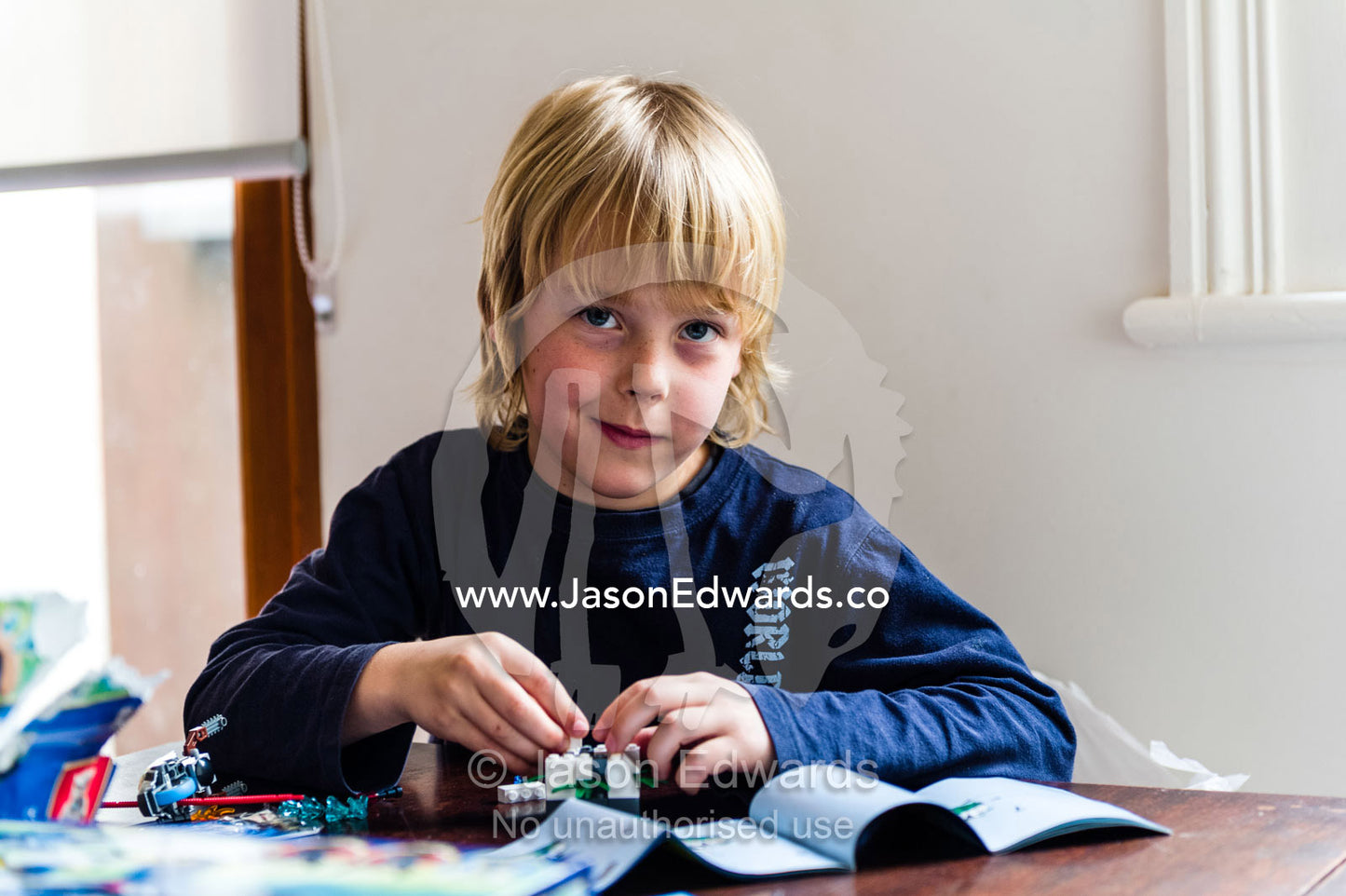 A boy constructing Lego at a dining table. Carlton North, Melbourne, Victoria, Australia.