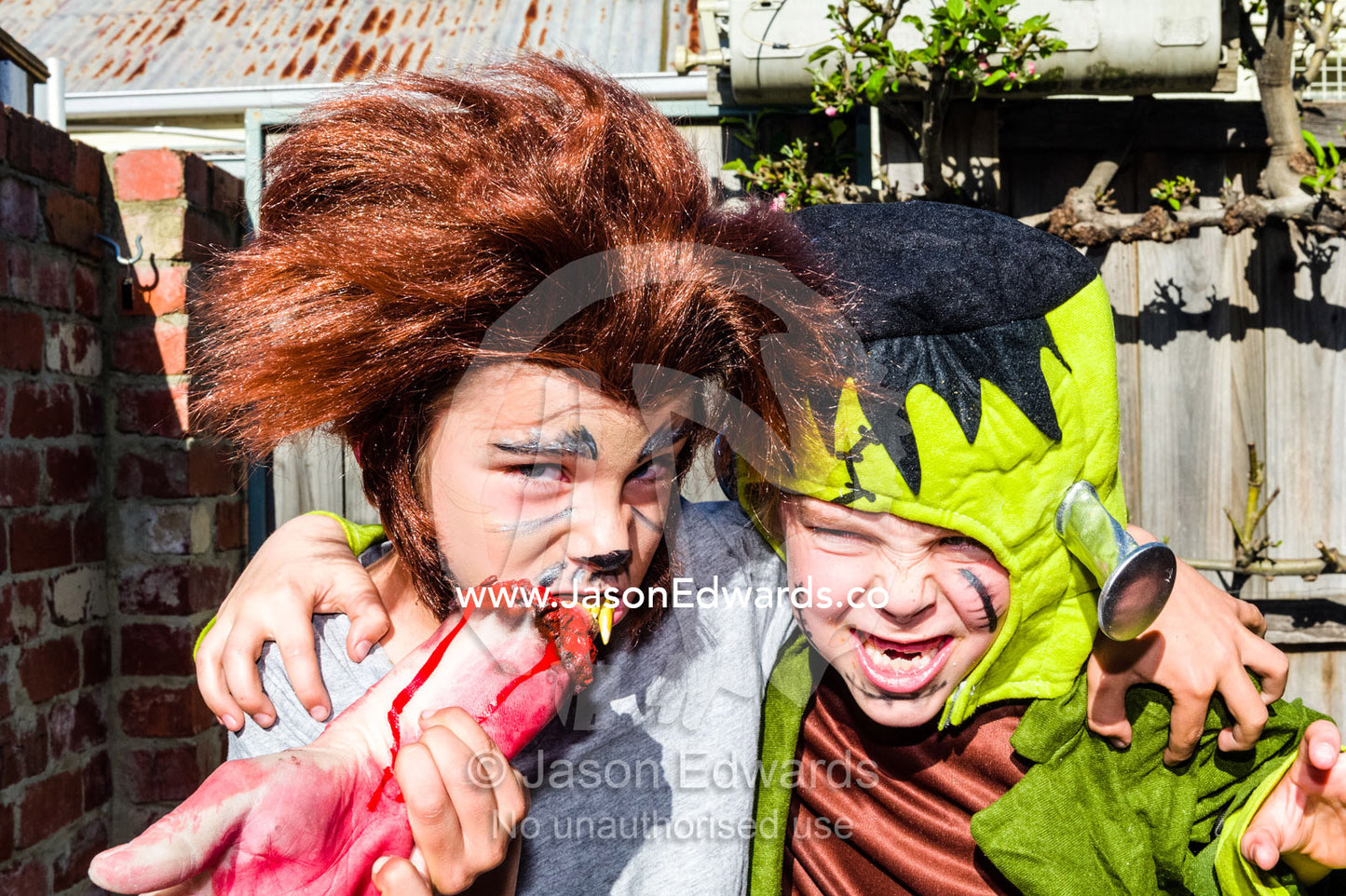 Two friends, a werewolf and Frankenstein, hug each other at a monster party. Carlton North, Melbourne, Victoria, Australia.