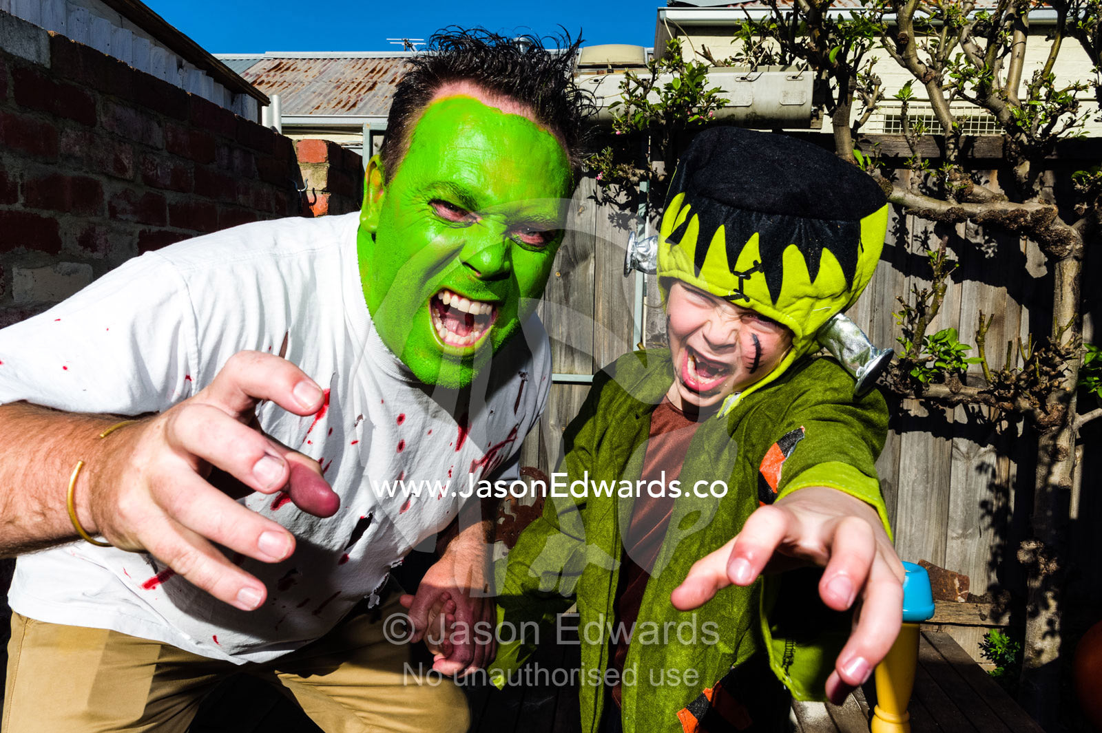 A dad and his son, the Hulk  and Frankenstein, attack the camera at a monster party. Carlton North, Melbourne, Victoria, Australia.