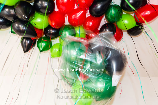 Opening a bag of party balloons to decorate a living room. Carlton North, Melbourne, Victoria, Australia.