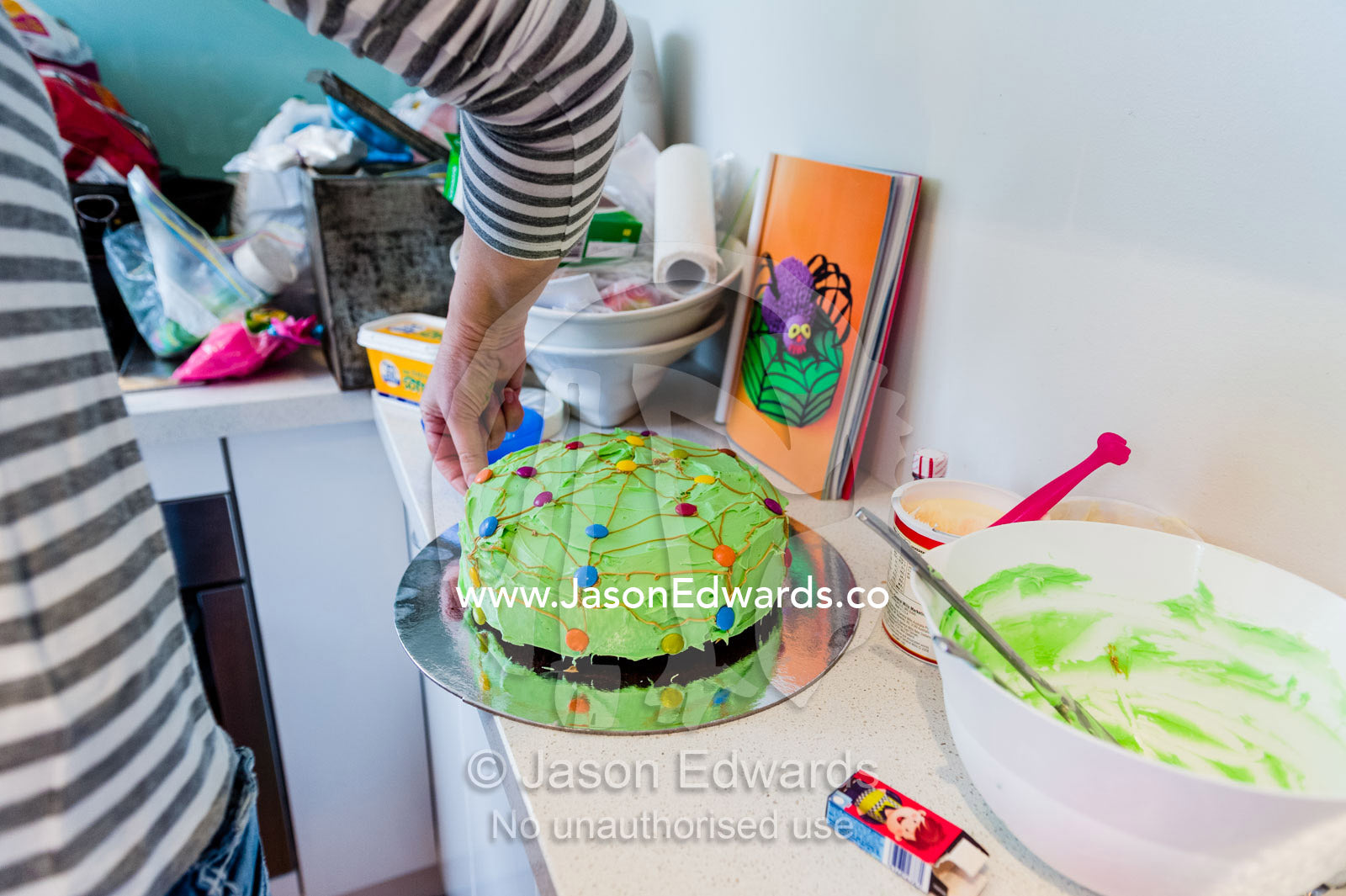 A mother decorating a birthday cake in the kitchen. Carlton North, Melbourne, Victoria, Australia.