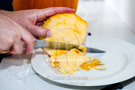 A mother carves the cap of a pumpkin for Halloween. Carlton North, Melbourne, Victoria, Australia.