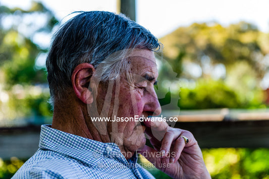 An elderly man rests on a shady balcony deep in thought. Castlemaine, Victoria, Australia.