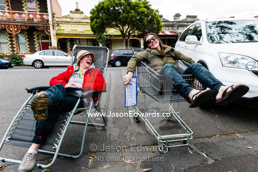 A school teacher and parent rest whilst monitoring students during an elementary school fundraising walkathon. Carlton North Primary School, Melbourne, Victoria, Australia.