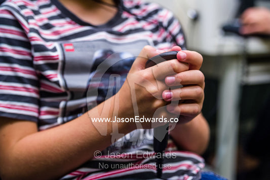A boy concentrating whilst he listens for sounds in headphones during a hearing test in an audiologist clinic. The University of Melbourne Audiology Clinic, Carlton, Melbourne, Victoria, Australia.