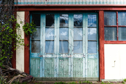 Peeling paint on weathered antique doors in a country town. Avenel, Victoria, Australia.