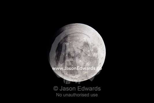 A shadow passes across the face of a full moon during an eclipse. Carlton North, Melbourne, Victoria, Australia.