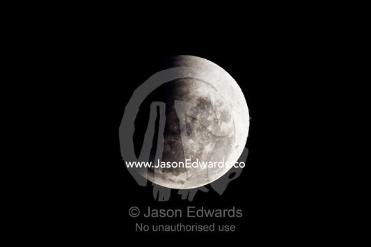 A shadow passes across the face of a full moon during an eclipse. Carlton North, Melbourne, Victoria, Australia.